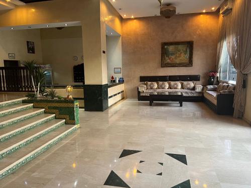eine Lobby mit Sofa und Treppe in einem Gebäude in der Unterkunft Hotel Majorelle in Marrakesch