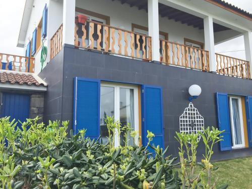a house with blue doors and a balcony at Casa Varanda do Mar in Capelas