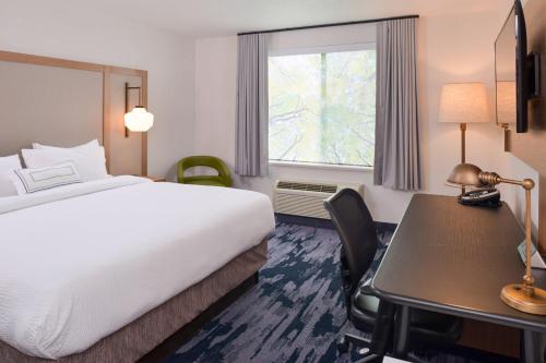 a hotel room with a bed and a desk and a window at Fairfield Inn & Suites by Marriott Pittsburgh New Stanton in New Stanton