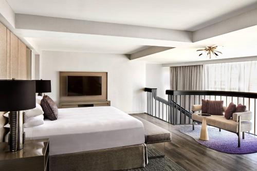 ein Schlafzimmer mit einem Bett, einem TV und einem Sofa in der Unterkunft San Francisco Marriott Marquis Union Square in San Francisco