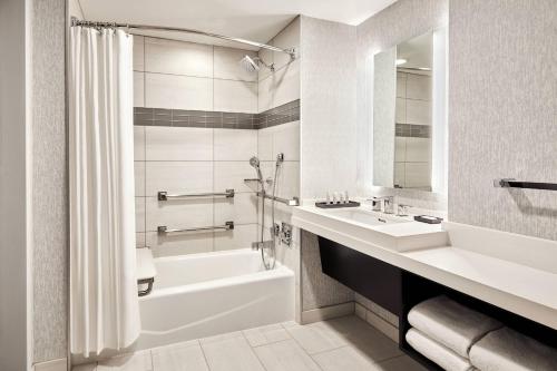 a bathroom with a white tub and a sink and a bath tubermottermottermott at San Francisco Marriott Marquis Union Square in San Francisco