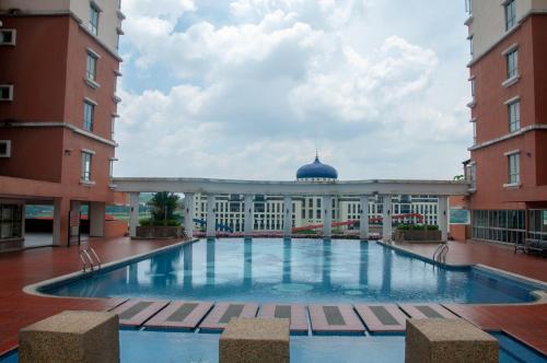 a large swimming pool in a courtyard between two buildings at Five H Family Service Apartment in Seri Kembangan