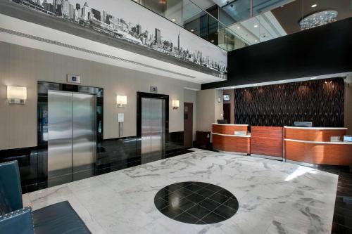 a lobby with a large marble floor and a elevator at Courtyard by Marriott New York Manhattan/ Fifth Avenue in New York