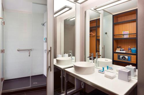 a bathroom with two sinks and a shower at Aloft Vaughan Mills in Vaughan