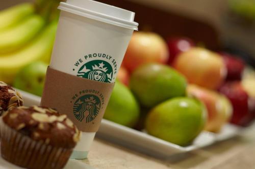a coffee cup sitting next to a tray of apples at Courtyard by Marriott New York Manhattan/ Fifth Avenue in New York