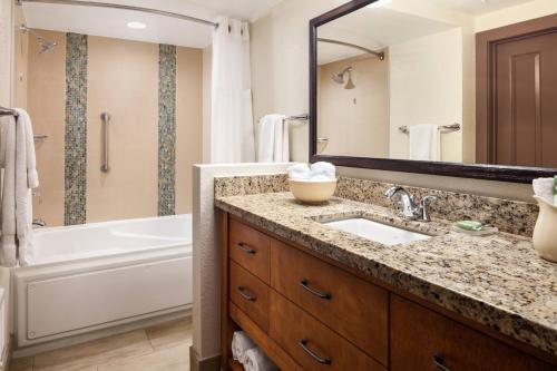 een badkamer met een wastafel, een bad en een spiegel bij Marriott's Mountain Valley Lodge at Breckenridge in Breckenridge