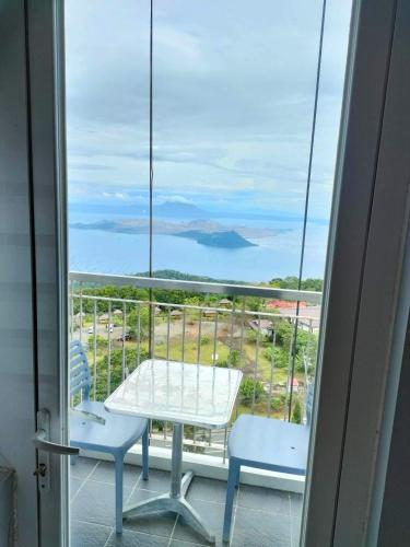 ein Tisch und Stühle auf einem Balkon mit Blick auf das Meer in der Unterkunft Smdc Wind Residences Tagaytay with Balcony 19th floor in Tagaytay