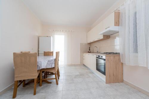 a kitchen with a table and a kitchen with white appliances at Apartments with a parking space Kraj, Pasman - 819 in Tkon