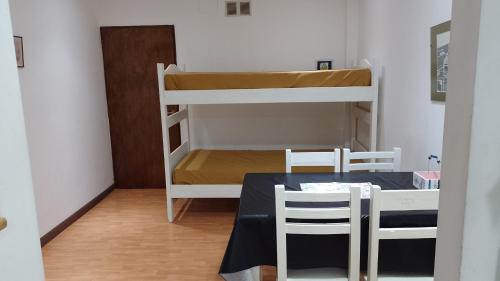 ein Zimmer mit einem Tisch und einem Etagenbett in der Unterkunft Céntrico A-05 in General Roca