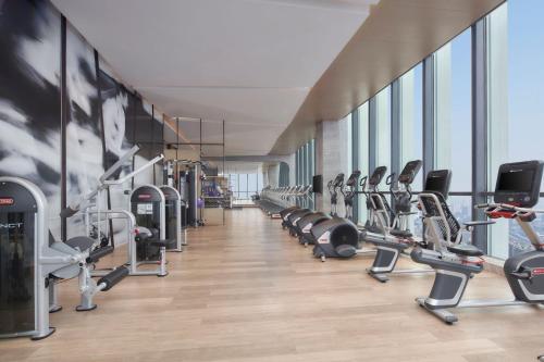 a gym with a row of treadmills and machines at Jinhua Marriott Hotel in Jinhua
