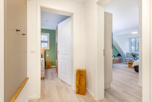 pasillo con puerta blanca y sala de estar en Suite Wind & Wellen, en Zingst