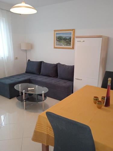 a living room with a blue couch and a table at Apartments by the sea Valun, Cres - 386 in Valun