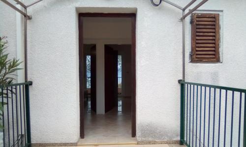 an open door of a house with a balcony at Apartments by the sea Valun, Cres - 386 in Valun