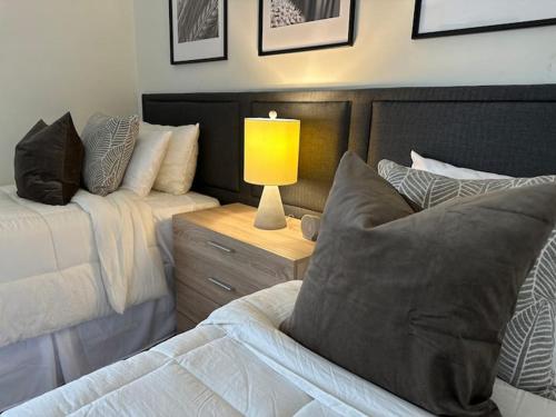 a bedroom with two beds and a lamp on a night stand at Vine City Home - Duplex - 3 Mins From GWCC & Mercedes- Benz Stadium in Atlanta
