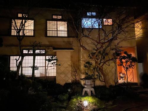 a house at night with a tree in front of it at 宮城野ハウス＆離れ in Gora