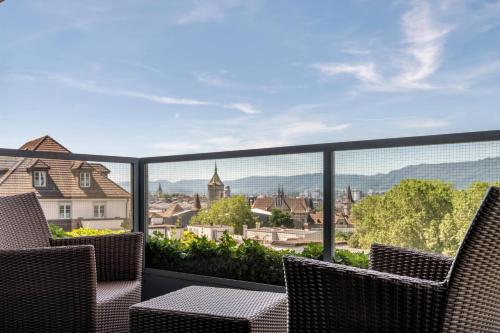 a balcony with chairs and a view of a city at Zurich Marriott Hotel in Zürich