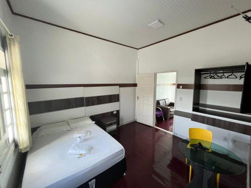 a room with a bed and a table and a mirror at POUSADA TORRE FORTE ac in Rio Branco