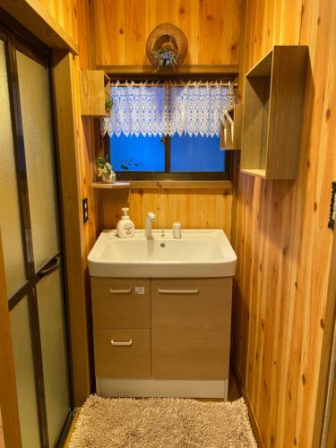 a bathroom with a sink and a window at 宮城野ハウス＆離れ in Gora
