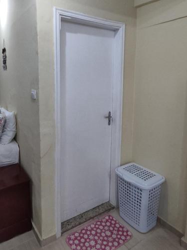 a white door in a room with a pink rug at Estúdio Mobiliado em Poços in Poços de Caldas
