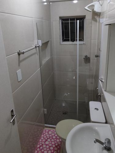 a bathroom with a shower and a toilet and a sink at Estúdio Mobiliado em Poços in Poços de Caldas