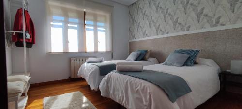 a bedroom with two beds and a window at Casa Angela in Las Fraguas