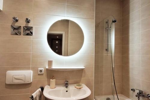a bathroom with a sink and a shower with a mirror at Design Altbauwohnung mit Balkon und Parkplatz in Leipzig