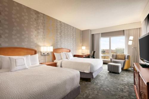 a hotel room with two beds and a window at Courtyard by Marriott Tysons McLean in Tysons Corner