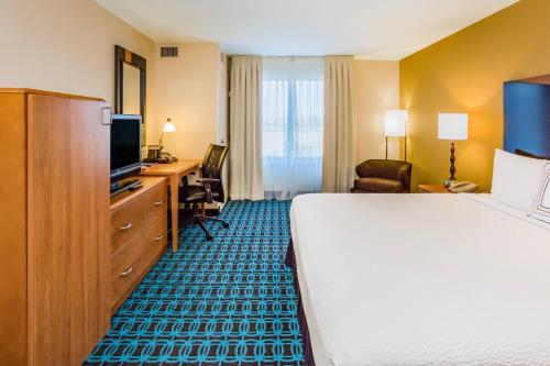 a hotel room with a bed and a desk and a television at Fairfield Inn and Suites Turlock in Turlock