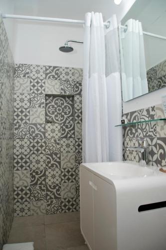 un bagno con tenda da doccia e lavandino di Casa Viento Hotel a Ciudad del Carmen