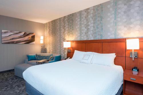 una habitación de hotel con una cama grande y una silla en Courtyard by Marriott Traverse City en Traverse City