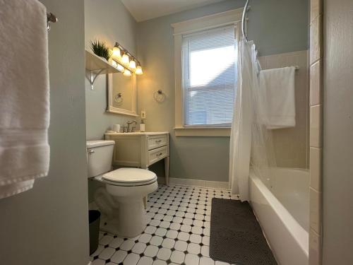 a bathroom with a toilet and a sink and a window at Luxury Lenox Townhouse in Memphis