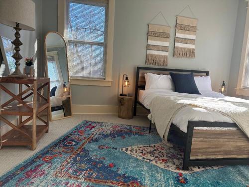 a bedroom with a bed and a mirror and a rug at Luxury Lenox Townhouse in Memphis