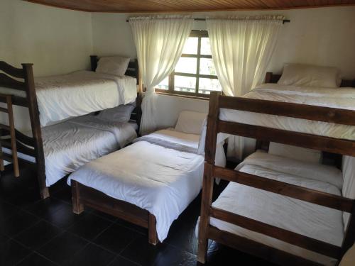 GüicánにあるHotel Brisas del Nevadoの二段ベッド4台、窓が備わる客室です。