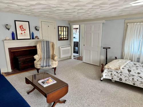 a living room with a bed and a chair and a table at The Loft in Salem