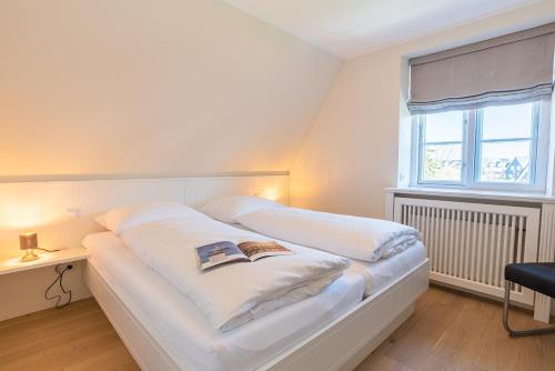- un lit blanc dans une chambre avec fenêtre dans l'établissement Dwarslöper, à Wrixum