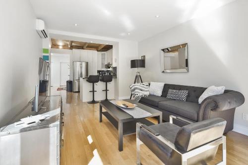 a living room with a couch and a table at STUNNING full APARTMENTS - stocked KITCHENS - WASHER & DRYERS - WORKSPACE PROVIDED - FAST WIFI - LOCATED on the FAMOUS ST Denis street - Near METRO MONT ROYAL in Montreal