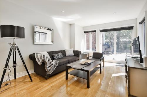 a living room with a couch and a table at STUNNING full APARTMENTS - stocked KITCHENS - WASHER & DRYERS - WORKSPACE PROVIDED - FAST WIFI - LOCATED on the FAMOUS ST Denis street - Near METRO MONT ROYAL in Montréal