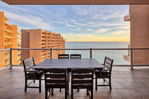a black table and chairs on a balcony with the ocean at Luxury Oceanview Condo - Las Palomas - Pool, Golf, Sandy Beach ! in Puerto Peñasco
