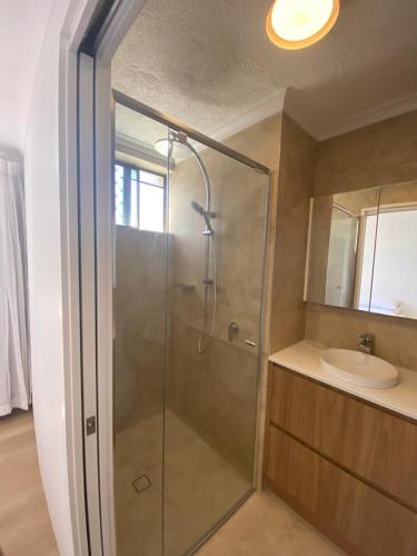 a bathroom with a shower and a sink at Enderley Gardens Resort in Gold Coast