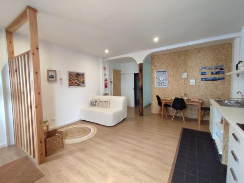 een woonkamer met een witte bank en een tafel bij Casa Hurtere in Horta