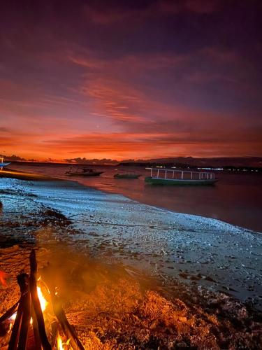 a boat on the water at sunset at Bohio Villas Gili Air in Gili Islands