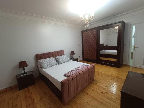 een slaapkamer met een bed, een bank en een spiegel bij Apartment closes to city stars شقة فخمة من سيتي ستارز in Caïro