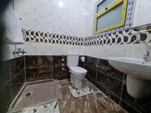 La salle de bains est pourvue de toilettes et d'un lavabo. dans l'établissement Hurghada appartment one room front of dream beach, à Hurghada