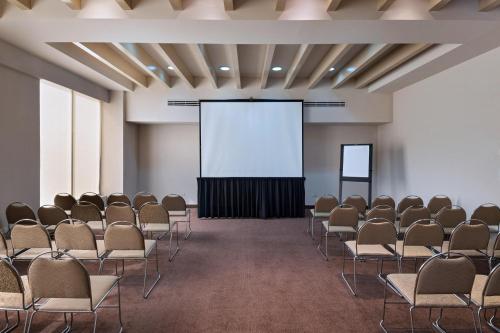 a lecture room with chairs and a screen at Four Points by Sheraton Galerias Monterrey in Monterrey