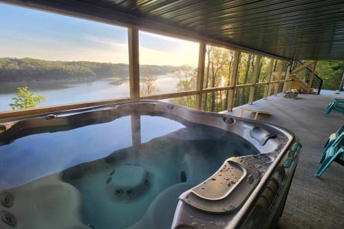 a hot tub on a balcony with a view of a river at Lakeview Happy Place - 10 Person House with HOT TUB on Lake Cumberland in Burnside