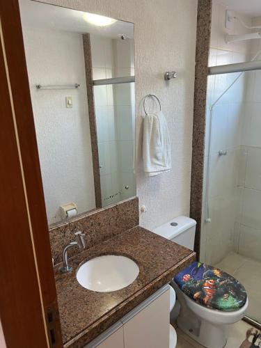 ein Badezimmer mit einem Waschbecken, einem WC und einem Spiegel in der Unterkunft Lindo flat sem custos adicionais in Natal