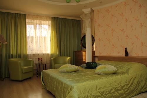 a bedroom with a bed and a table and a chair at Guesthouse Vizit in Chaykovskiy