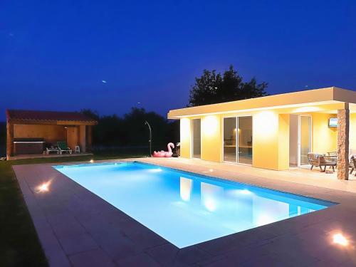 una piscina di fronte a una casa di notte di Rural holiday home in Netos Almagreira with shared pool 