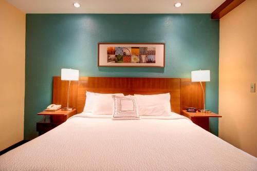 a bedroom with a large bed with a blue wall at Comfort Inn & Suites Green Bay Stadium Area in Green Bay