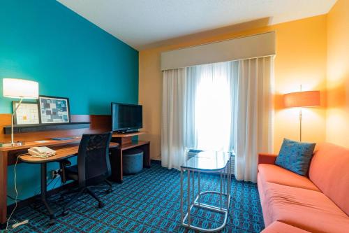 a hotel room with a couch and a desk with a computer at Comfort Inn & Suites Green Bay Stadium Area in Green Bay